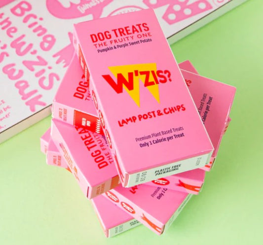 Stack of pink 'W'iz?' dog treat boxes on a green surface